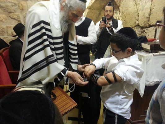 A Young boy's first time putting on tefillin!