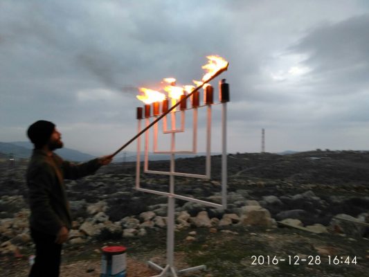 Lighting of the Menorah outside of renovated synagogue in West Kfar Tapuach